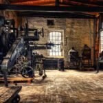 Ancien atelier industriel avec machines, briques, fenêtres et sol en bois