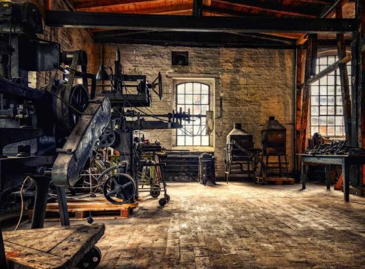 Ancien atelier industriel avec machines, briques, fenêtres et sol en bois