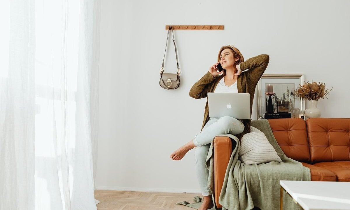 Une femme travaille à distance depuis son salon détendue